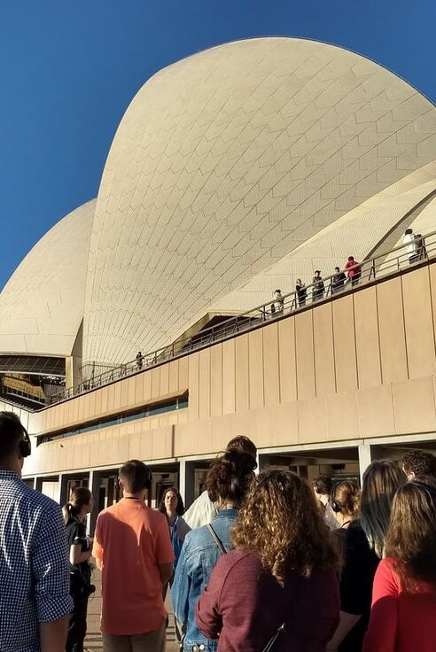 Engineering students look up at the Sydney Opera House